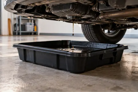 Drip tray for garage floor catching an oil drip under a parked car
